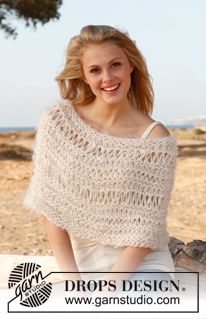 a woman sitting on the ground wearing a shawl and smiling at the camera with her hands in her pockets