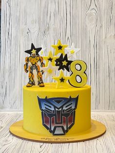 a birthday cake decorated with stars and an image of a transformer head on top