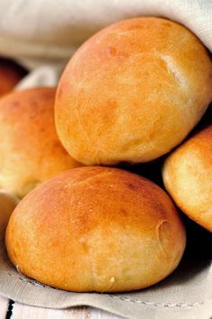 several round bread rolls stacked on top of each other in a pile with linen napkins