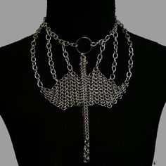 Unleash your inner dragon with the Dragon's Embrace Chainmail Necklace, a mesmerizing piece perfect for renaissance fairs and fantasy outfits. Crafted from silver anodized aluminum jump rings, this necklace features a stunning dragon intricately woven out of chainmail, showcasing exceptional artistry and detail. The Dragon's Embrace Chainmail Necklace is not just an accessory but a statement of strength, mystery, and timeless elegance. Let this unique piece adorn your neck, capturing the essence of mythical beauty and adding a touch of enchantment to your ensemble. Punk Style Metal Body Jewelry With Chain, Silver Punk Jewelry For Cosplay, Gothic Silver Jewelry For Cosplay, Silver Gothic Jewelry For Cosplay, Silver Chain Choker For Festivals, Gothic Metal Chain Body Jewelry, Gothic Silver Metal Body Jewelry, Gothic Metal Jewelry For Fantasy Events, Silver Gothic Metal Body Jewelry