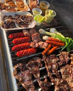 an outdoor grill with meat, vegetables and other foods cooking on it's sides