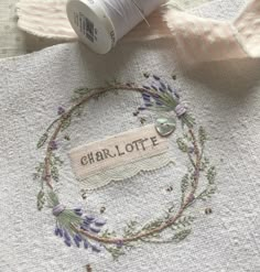 some thread is laying on top of a piece of fabric with the word charlotte written in it