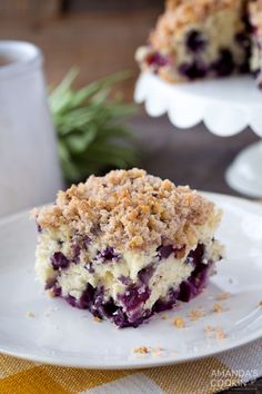 a piece of blueberry crumb coffee cake on a white plate with a fork