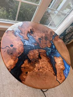 a wooden table sitting on top of a carpeted floor in front of a window