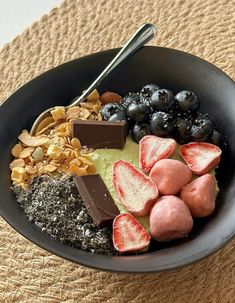 a bowl filled with fruit, nuts and chocolate