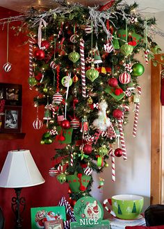 a christmas tree with ornaments hanging from it's branches and decorations on the top