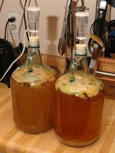 two bottles filled with liquid sitting on top of a wooden table