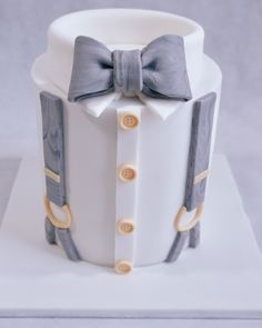 a white cake with a bow tie and suspenders on it