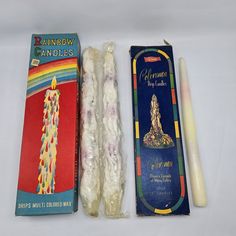 two candles, one with a candle holder and the other with a box