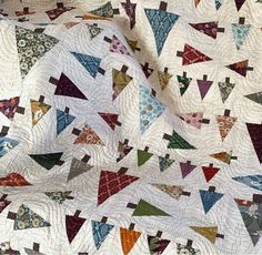 a quilt with many different colored triangles on it