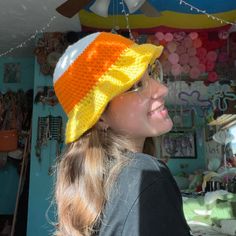 a woman wearing a knitted hat and glasses in a room with balloons hanging from the ceiling