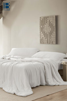 an unmade bed with white sheets and pillows in a large room next to a painting on the wall