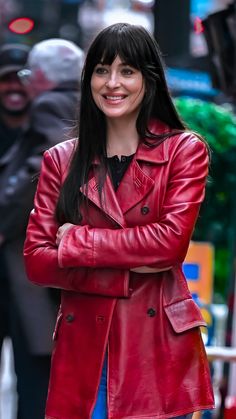 a woman in a red leather jacket is smiling