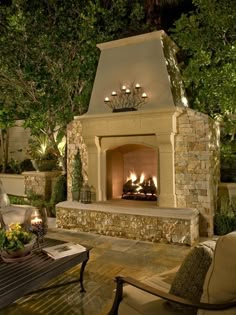 an outdoor fireplace is lit up at night