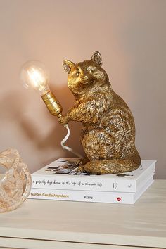 a gold bear lamp sitting on top of a stack of books