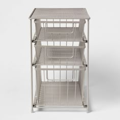 a white metal shelf with three baskets on each shelf and one basket in the middle