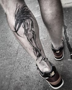 a man's leg with a black and white tattoo on it