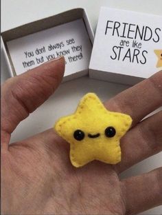 a person's hand holding a small yellow star brooch