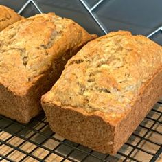 three loaves of bread sitting on top of a cooling rack