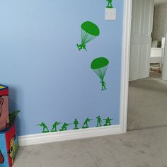 a room with blue walls and green silhouettes on the wall, two children's toys