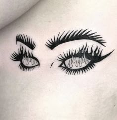 an eye tattoo on the side of a woman's stomach