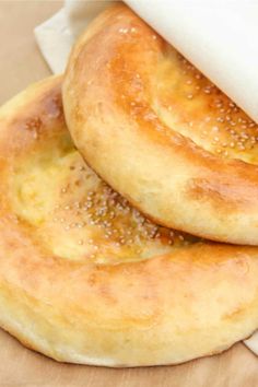 two bagels sitting on top of a piece of parchment paper next to each other