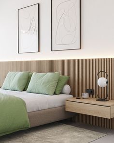 a bed with green pillows and two pictures on the wall above it, next to a night stand