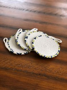 three woven coasters sitting on top of a wooden table