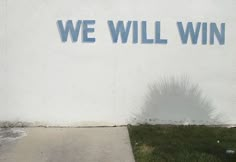 we will win written on the side of a building with a fire hydrant next to it