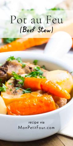 pot au feu beef stew with carrots, potatoes and parsley in a white bowl