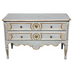 an antique chest with two drawers and gold trimmings on the top, against a white background