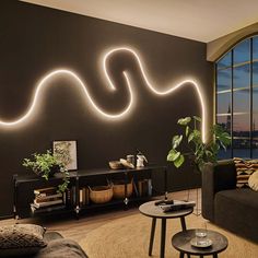 a living room filled with furniture and a large window covered in bright white lights next to a black wall