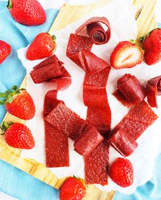 sliced strawberries on a cutting board next to cut up pieces of cake and strawberries