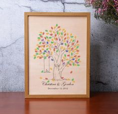 a wooden frame with an image of a family tree on it and flowers in the background