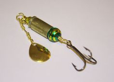 a fishing lure with a green glass bead hanging from it's hook on a white surface