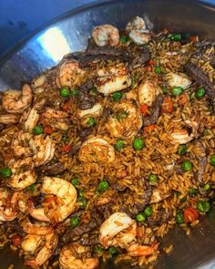 a large metal bowl filled with rice and shrimp