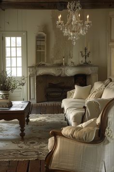 a living room filled with furniture and a chandelier hanging from the ceiling next to a fire place