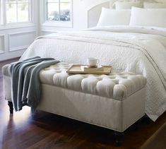 a white bed sitting on top of a wooden floor