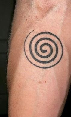 a man's arm with a tattoo that has an image of a spiral on it