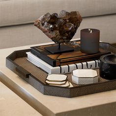 a tray that has some food on it and a candle in the middle with rocks