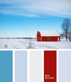 a red barn sits in the middle of a snowy field