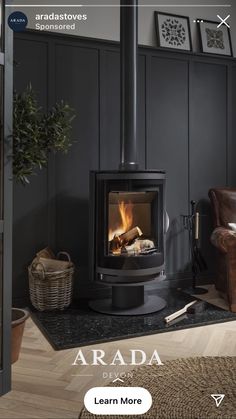 a wood burning stove sitting inside of a living room next to a brown leather chair