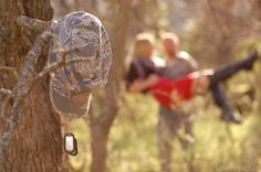 two people in the woods one is holding an object and the other is hanging from a tree