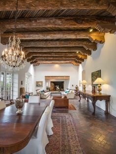 a large living room with wooden beams and chandelier