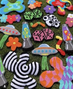 various felt toys are laid out on the ground in different patterns and colors, including flowers