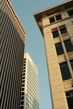 two tall buildings next to each other in front of a blue sky with no clouds