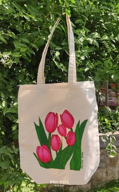 a white bag with pink tulips painted on it