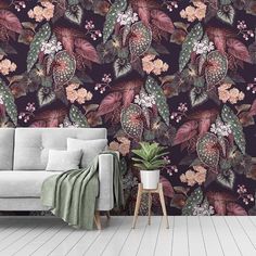 a living room with a couch, plant and wallpaper