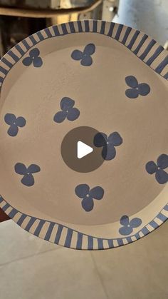 a paper plate with blue flowers on it is being held by someone's hand