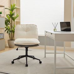 a white chair sitting in front of a desk with a laptop computer on top of it